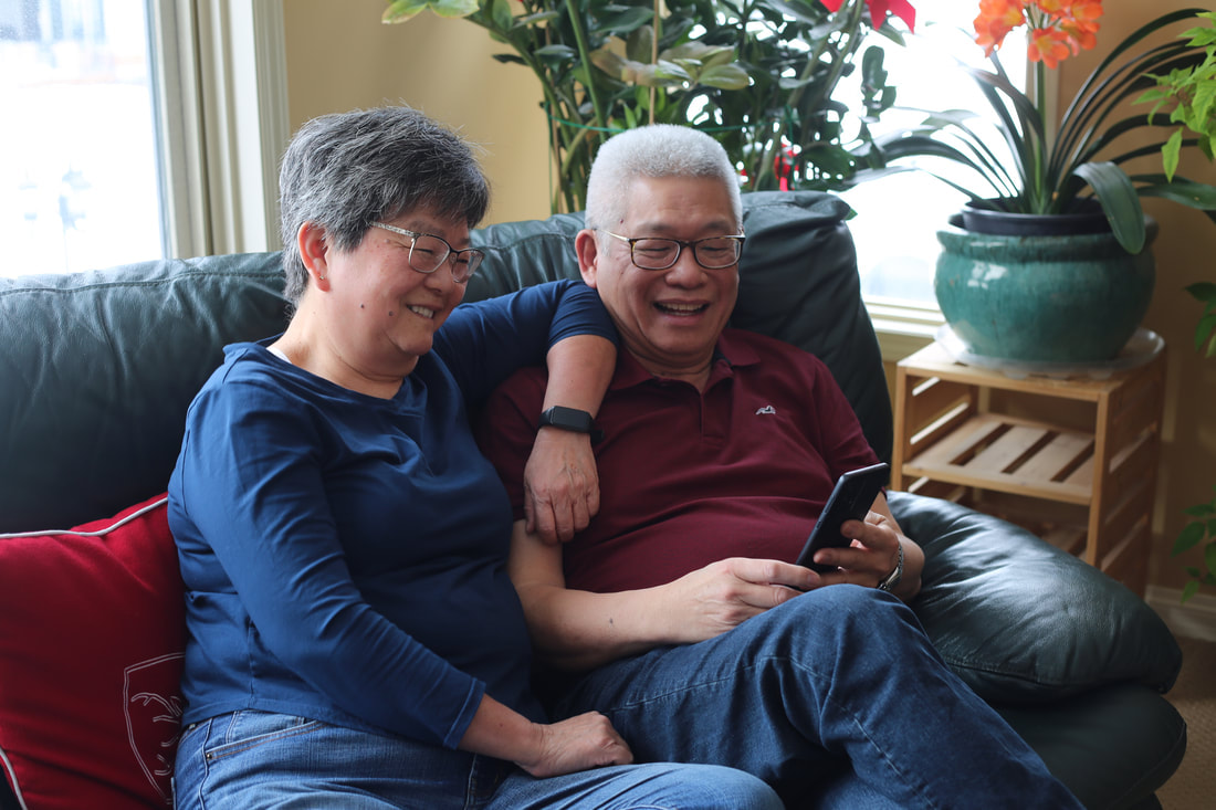 image of two seniors looking at their phone smiling